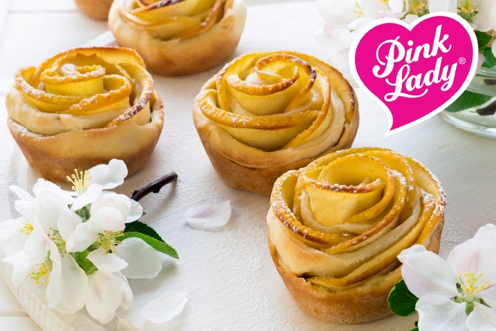 Apple slices shaped in blossoms and set within a pastry base. A heart with the words "Pink Lady" sits in the upper right corner.
